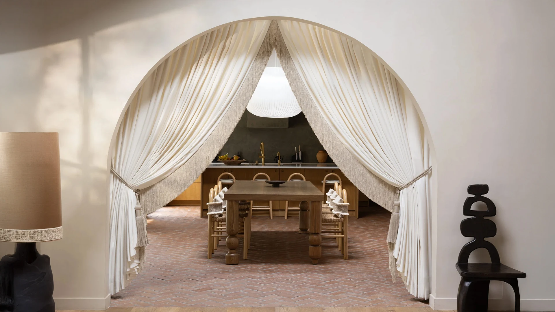 Elegant arched curtains styled with boho-inspired tie back tassels in cream tones—perfect for modern soulful homes.